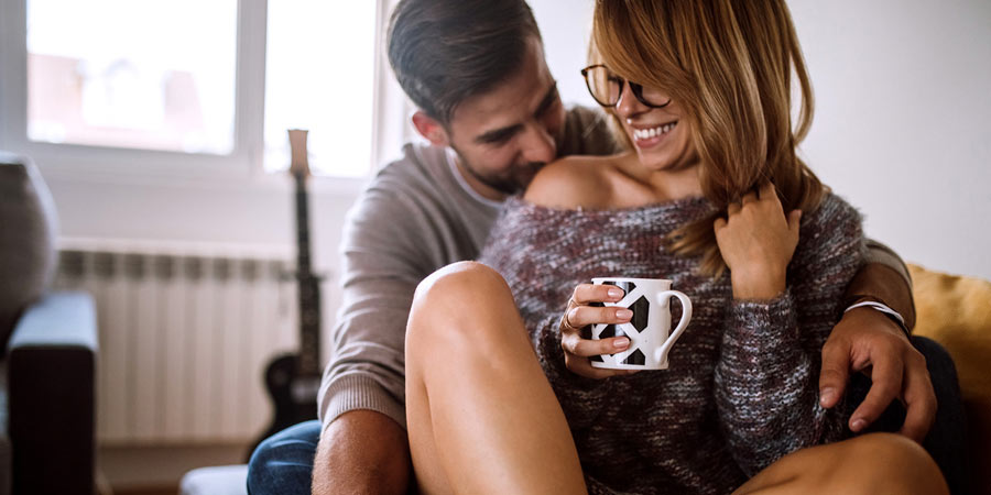 Young couple sharing an intimate moment while sharing a coffee
