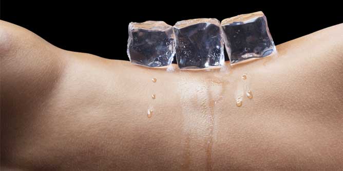Three ice cubes melting on a naked torso
