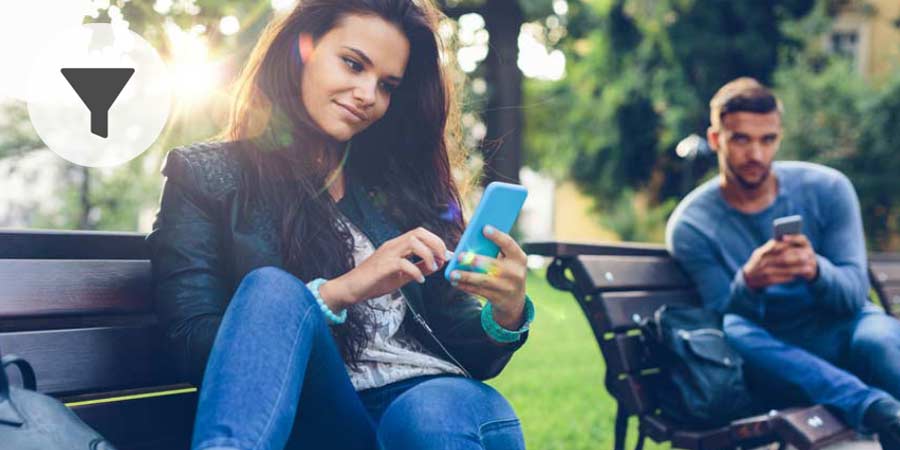 Young couple messaging back and forth on their mobile devices