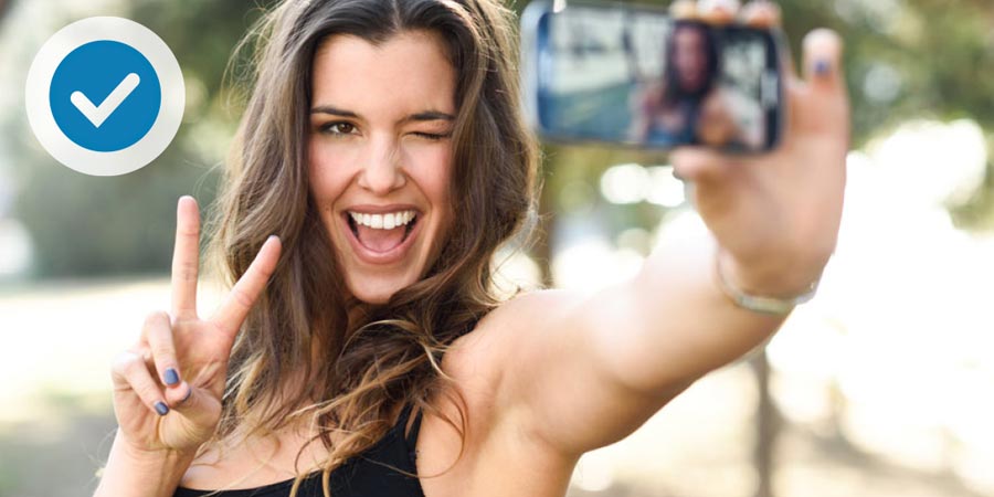 Young woman using mobile phone to profile verify with hand gesture.