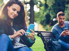 Young couple messaging back and forth on their mobile devices