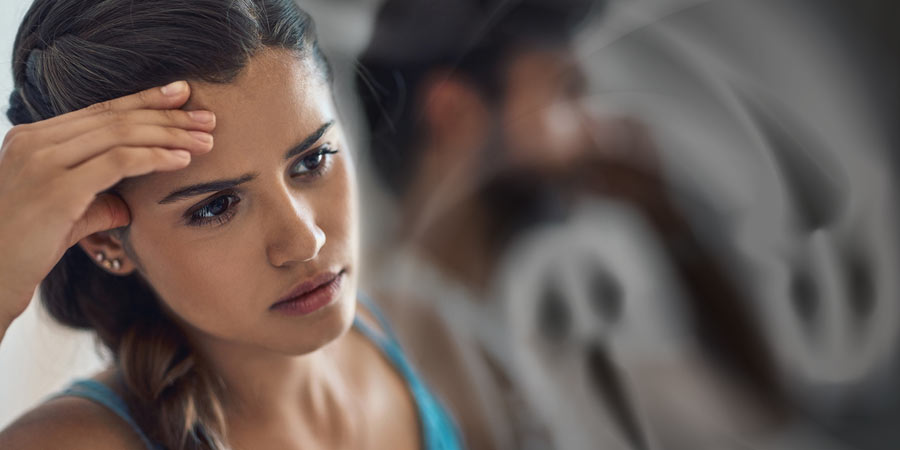 Woman looking lonely and sad with the ghost of her boyfriend in the background