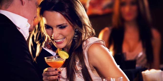 Attractive couple flirting over cocktails at a bar