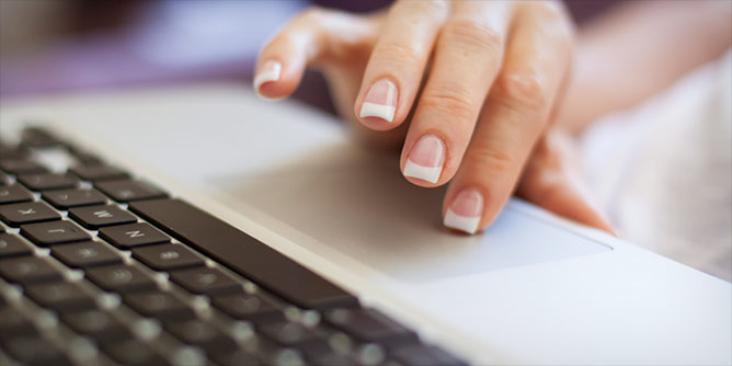 Woman with French manicure doing social media on her laptop