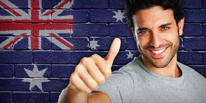 Brick wall painted with an Australian flag and a man giving a thumbs up sign