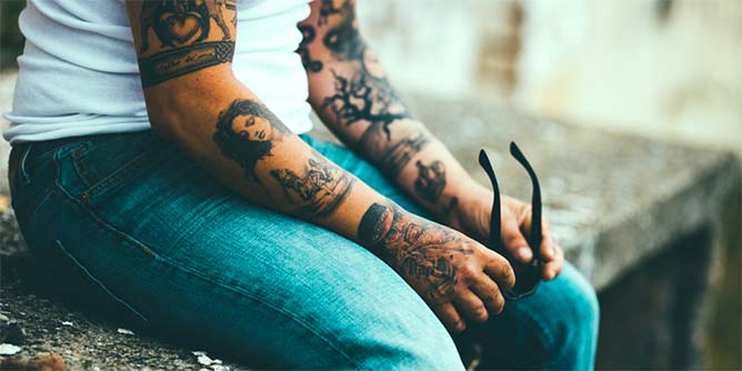 Man with tattooed arms wearing jeans