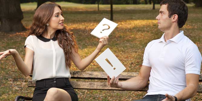 Man and woman sitting on a park bench discussing the number of sex partners they have had