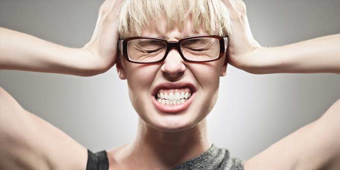 Frustrated single woman holding her hands to her head about to scream