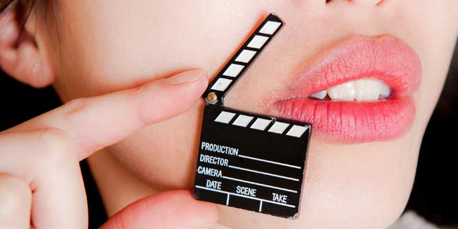 Woman holding a miniature clapperboard from a porn movie set