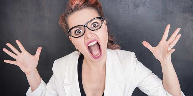 Woman in a labcoat and glasses screaming at the camera