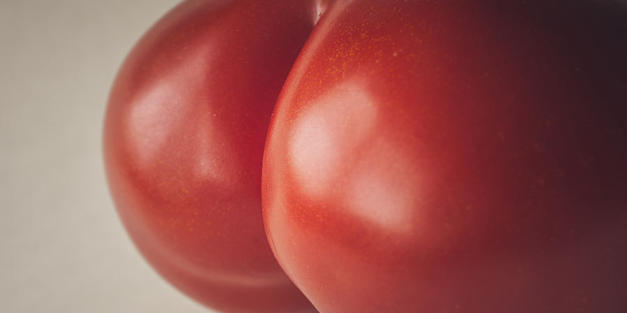 Photo of a ripe tomato cropped so it looks like buttocks
