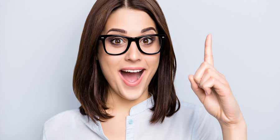 Woman with a surprised look pointing her finger into the air 