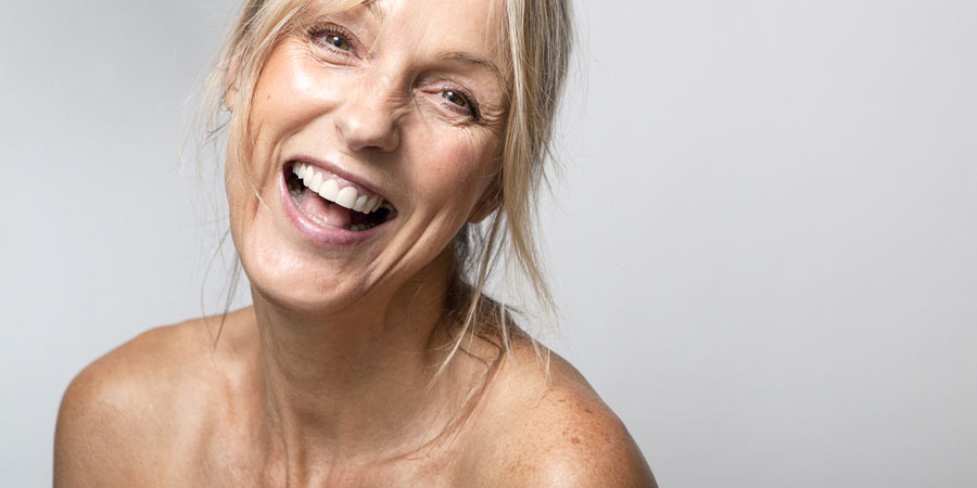 Attractive mature woman with blonde hair laughing at the camera