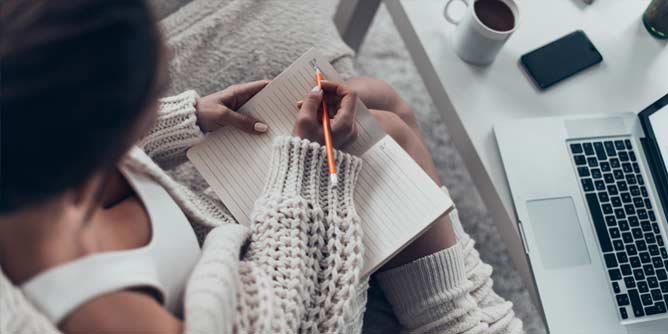 Woman writing an erotic story in a notebook 