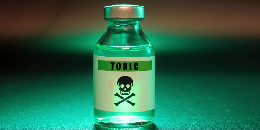 Glass bottle of green poison labelled toxic