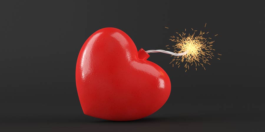 Red plastic heart made to look like a bomb which has a burning fuse