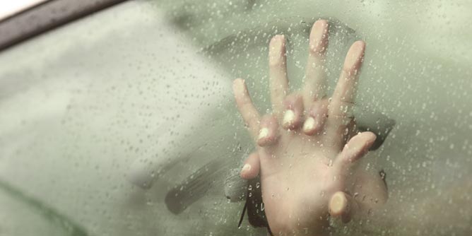 Couple's clasped hands against a steamy car window as they have car sex