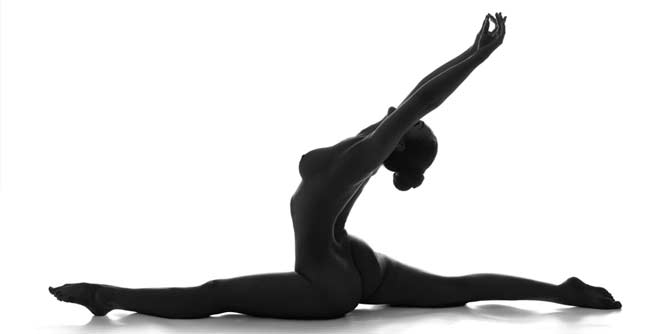 Silhouette of a woman doing yoga naked