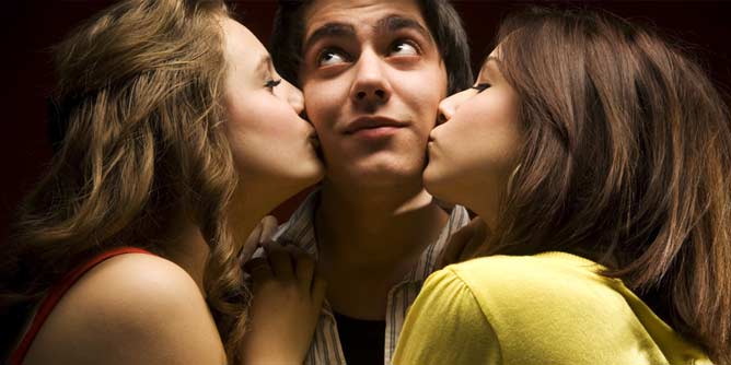 Man being kissed on both cheeks by two women