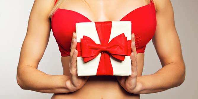 Woman in a red bra holding a Valentine's Day present with a red bow