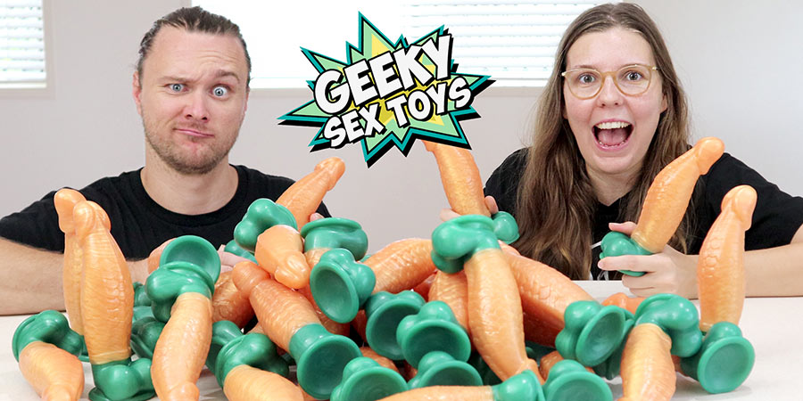 The owners of Geeky Sex Toys website holding a bunch of dildos