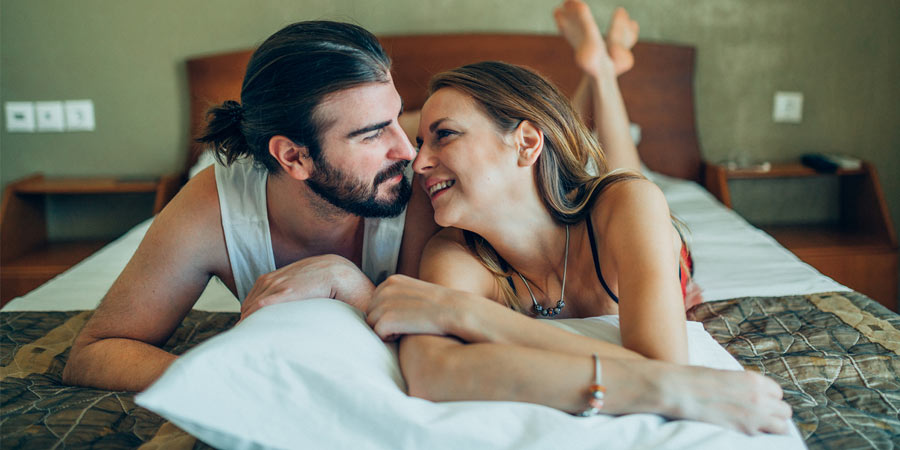 Couple lying in bed looking into each other's eyes