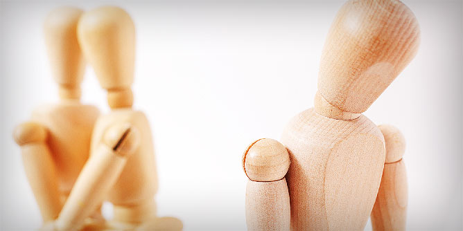 Three wooden peg figures indicating a couple and someone turning away from them